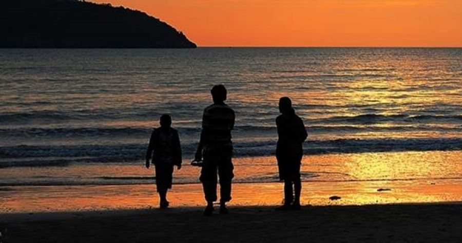 Una familia paseando por la orilla al atardecer  masfacilabogados
